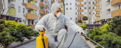 Técnico aplicando dedetização em área externa residencial