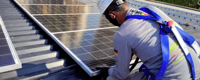 Técnico instalando painel solar em telhado residencial